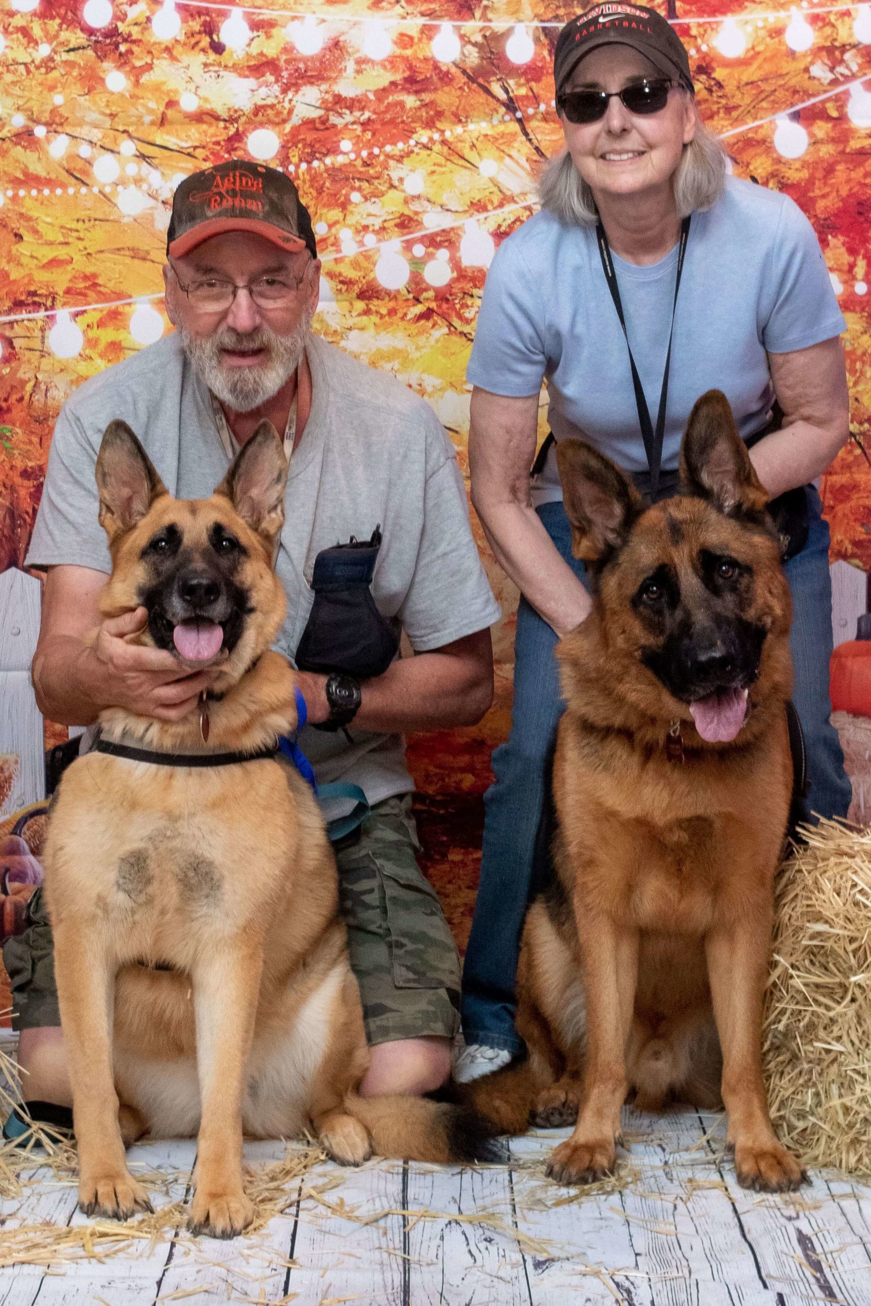 two people with two german shepherds